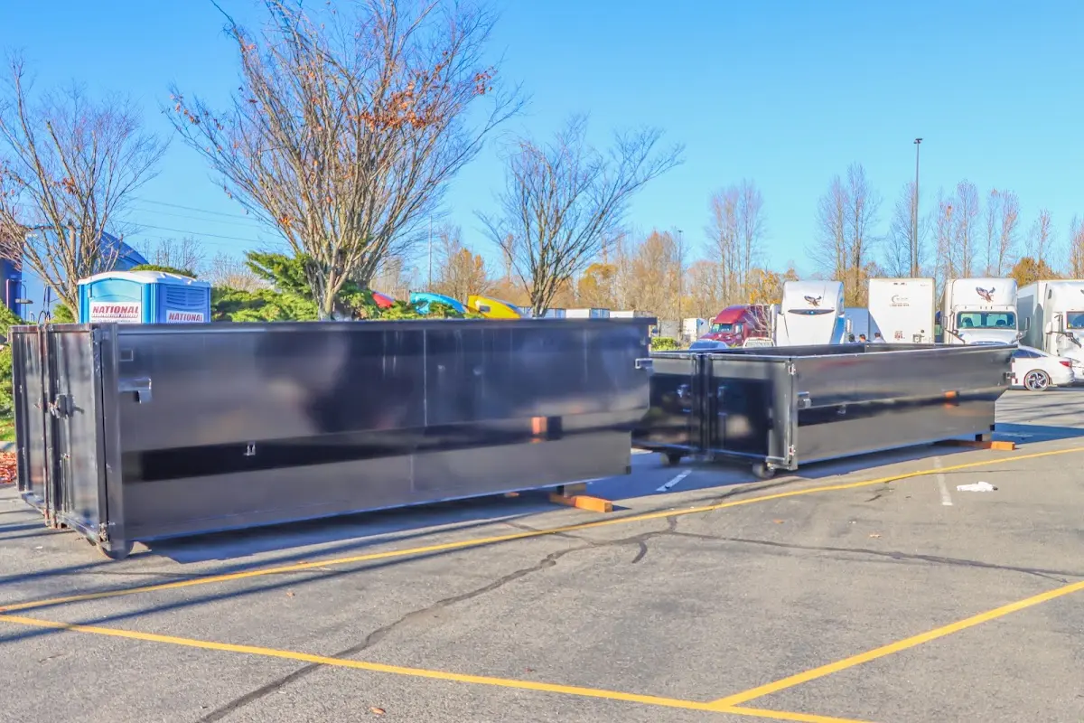 Professional dumpster rental service with roll-off container on residential driveway in Ware